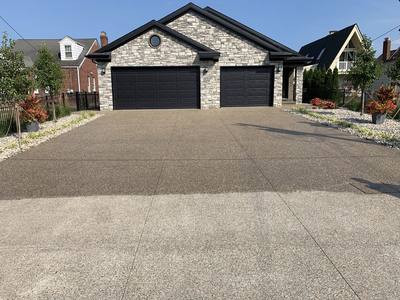 Exposed aggregate concrete surface being washed and sealed for a decorative finish