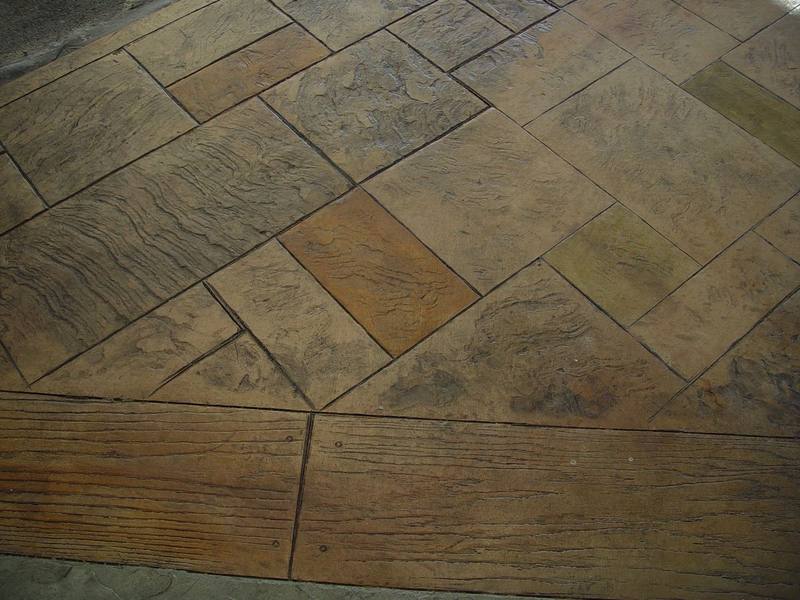 Finished stamped concrete patio in an ashlar slate pattern with a wood-plank border