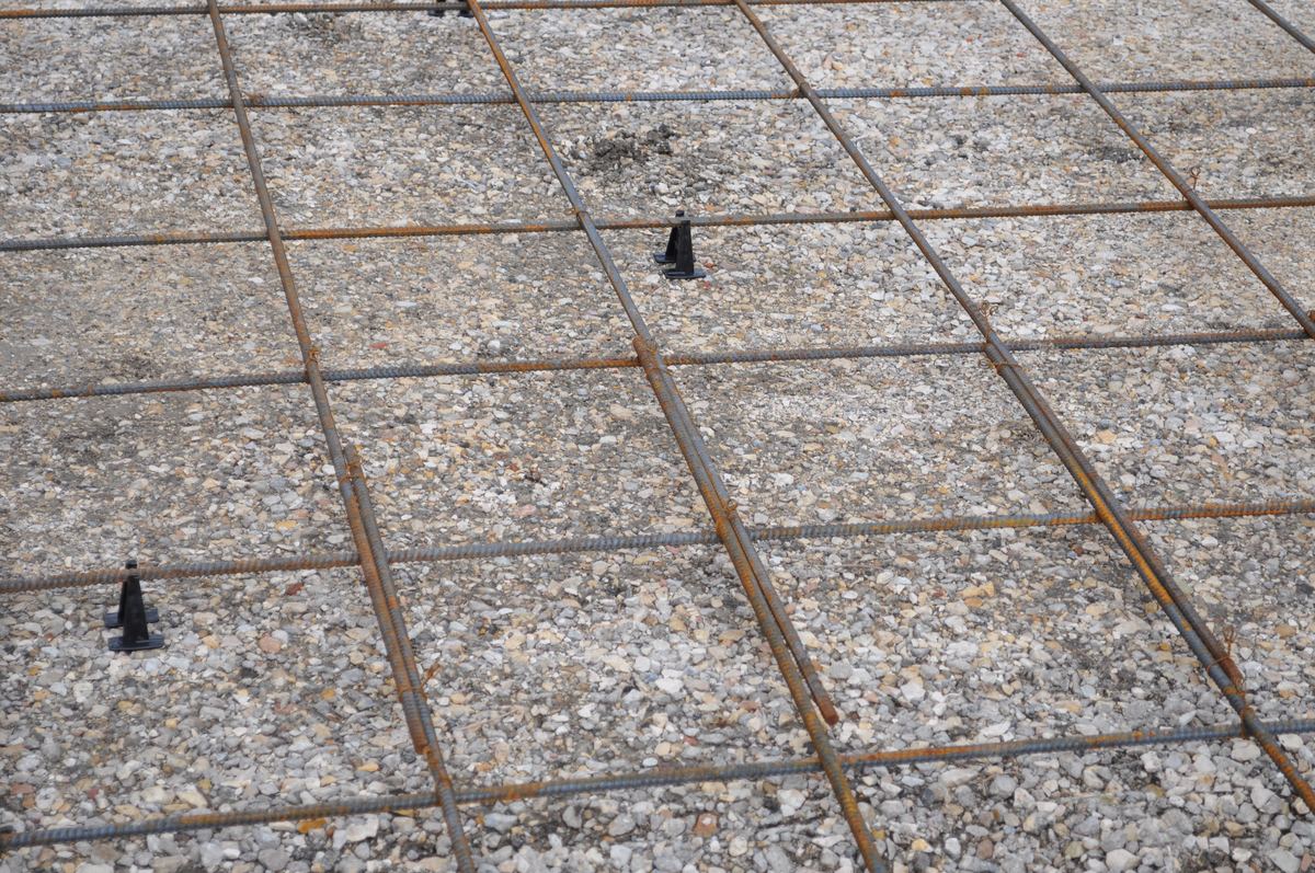 Steel rebar reinforcement grid laid out before a concrete driveway pour